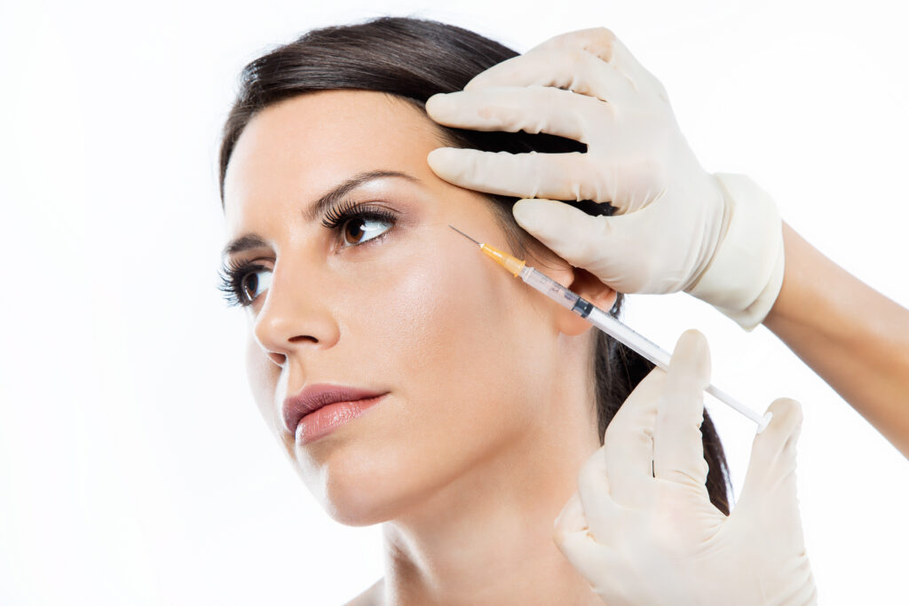 Young woman getting botox cosmetic injection in her face