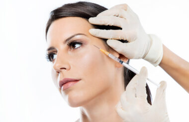 Young woman getting botox cosmetic injection in her face